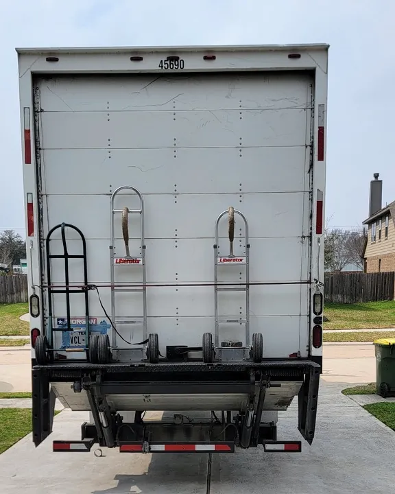 Back of the Stack Haus box truck with a hand truck and two appliance dollies mounted on the liftgate