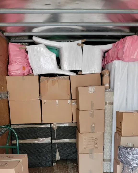 Inside of a box truck packed tightly with moving boxes and wrapped furniture